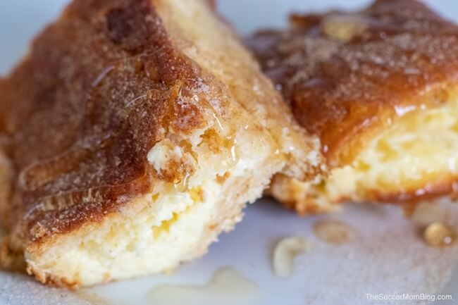 Sopapilla Cheesecake Bars is one of my husband's most requested desserts of all time! Real, creamy cheesecake layered between flaky croissant dough and topped with cinnamon, sugar, and honey - it's heavenly!