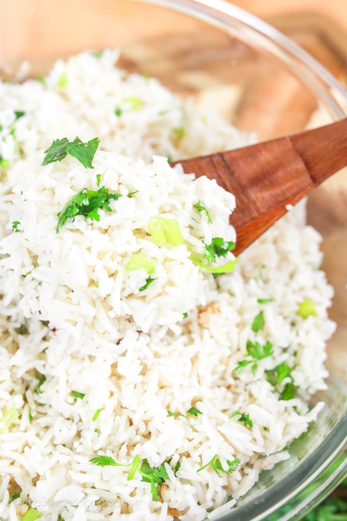 glass mixing bowl with coconut rice and wooden spoon