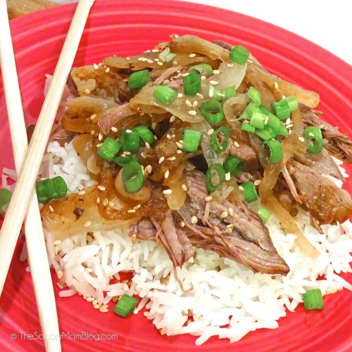 plate of Asian style slow cooker beef roast on rice with chopsticks