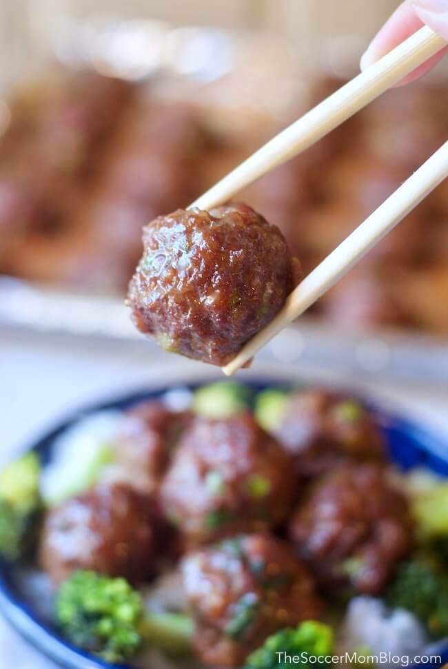Close up of Korean BBQ meatball held by chopsticks