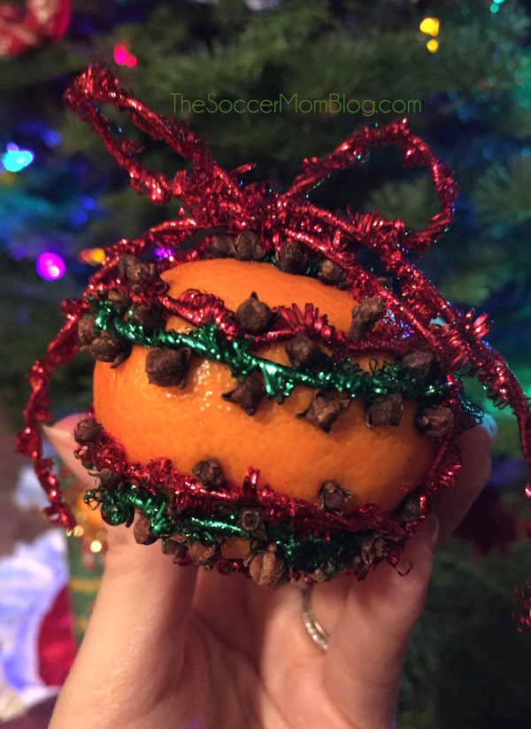 How to make beautiful and fragrant orange pomander ornaments. A craft easy enough for kids, but absolutely gorgeous on any tree!