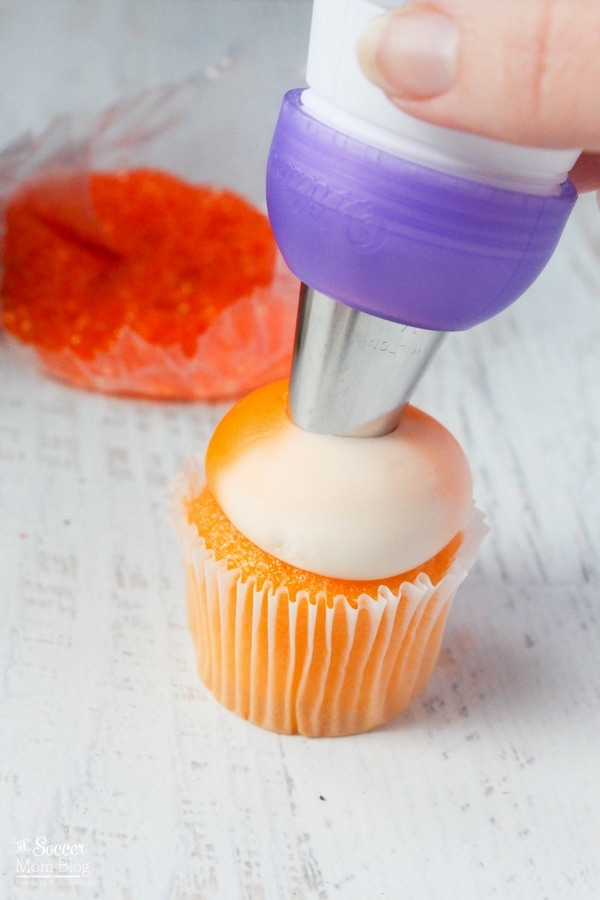 frosting orange and white Halloween cupcakes