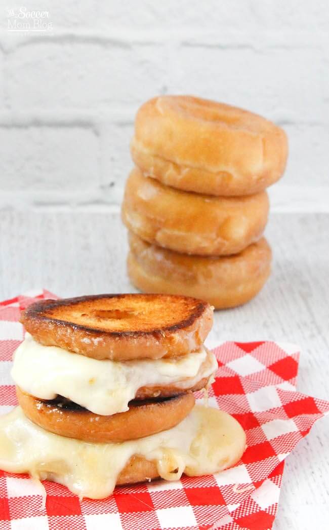 gooey cheesy donut grilled cheese with a stack of donuts behind it