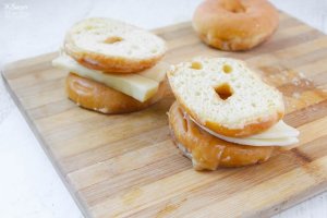 layering a grilled cheese sandwich with glazed donut halves as the bread
