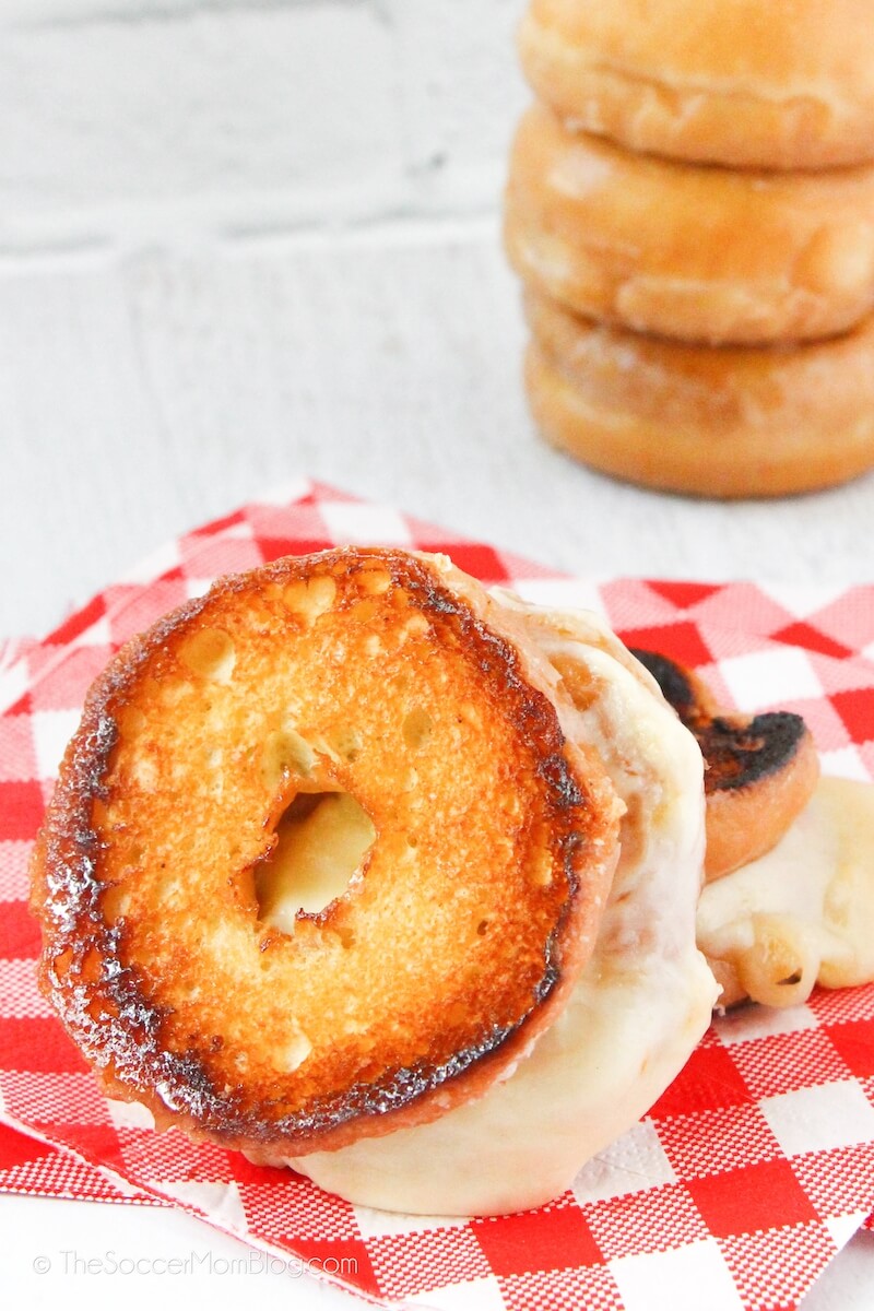 grilled cheese sandwich made with a donut, stack of donuts in background