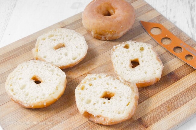 glazed donuts, sliced in half on a wooden cutting board