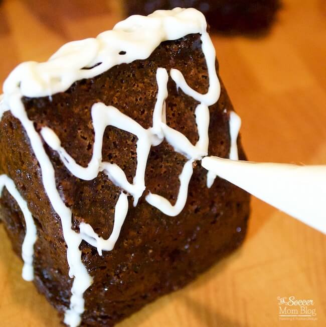 These Mini Gingerbread House Cakes taste just as delicious as they look! Moist, spicy gingerbread cake (gluten free!) beautifully decorated to make a show-stopping Christmas dessert centerpiece!