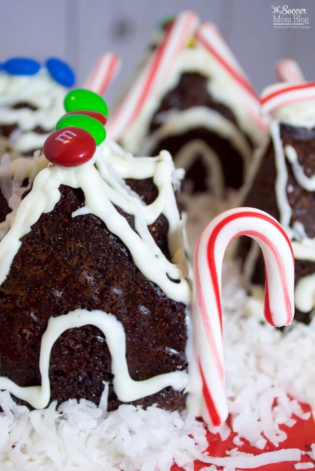 These Mini Gingerbread House Cakes taste just as delicious as they look! Moist, spicy gingerbread cake (gluten free!) beautifully decorated to make a show-stopping Christmas dessert centerpiece!