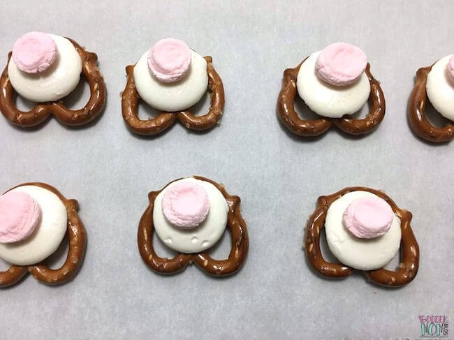 mini pretzel twists layered with a white chocolate melting wafer and pink mini marshmallow