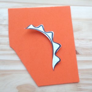 tracing dinosaur spikes onto orange craft foam