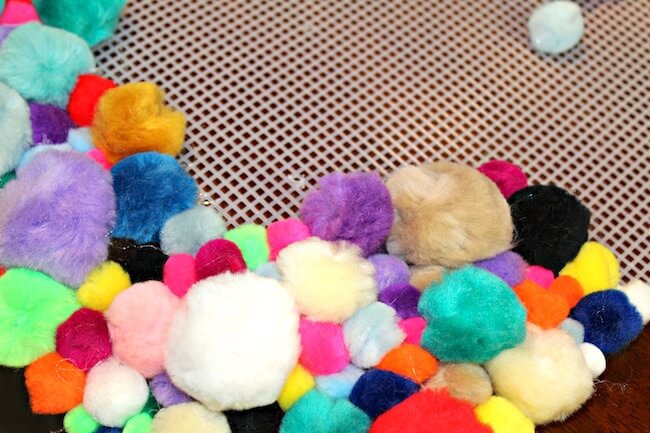 Add a burst of color to any room with this vibrant Pom Pom Rug - an easy DIY craft that's perfect for a kids room, bathroom, reading nook, or anywhere!