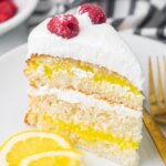 slice of lemon layer cake, topped with whipped cream and raspberries