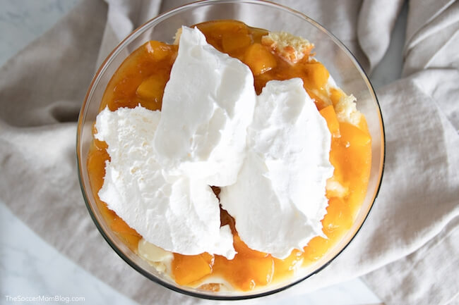 layering peach trifle dessert in bowl