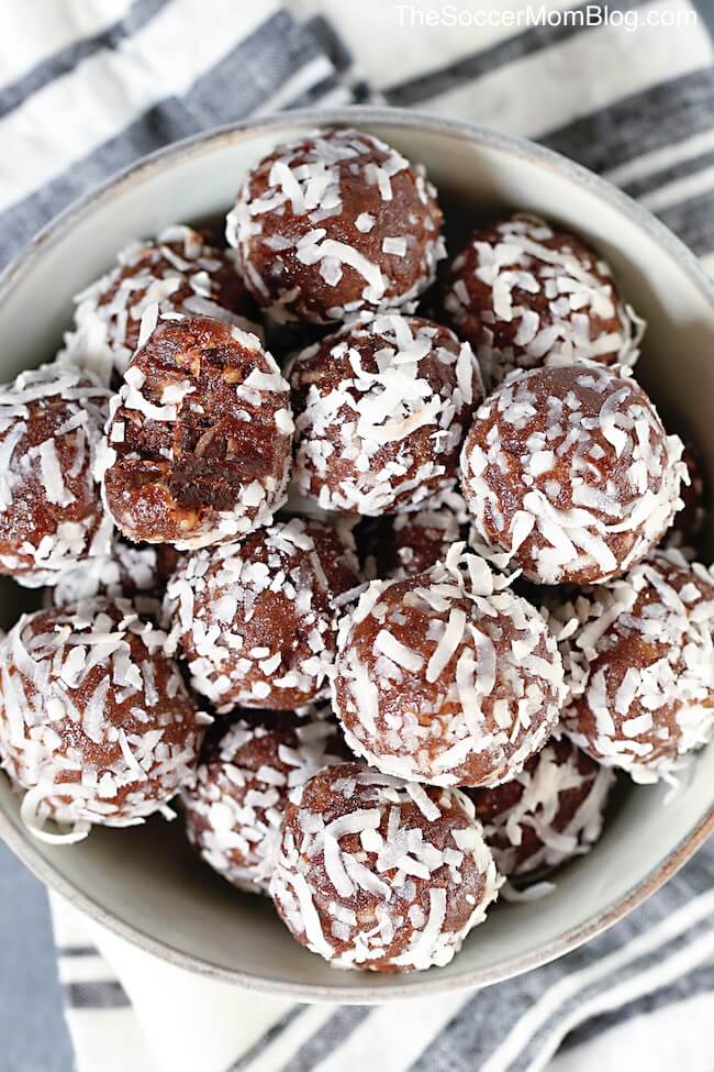 bowl of chocolate protein balls rolled in shredded coconut