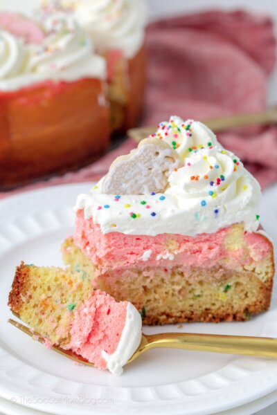slice of layered funfetti cheesecake with a bite on fork