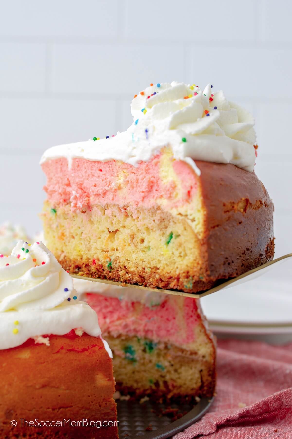pulling a slice of funfetti cheesecake with a cake slicer