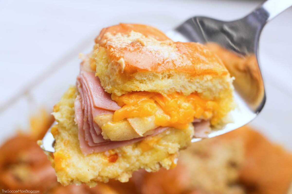 An irresistible combination of savory and sweet — these Buttery Baked Ham, Apple, & Cheddar Sliders are the perfect hearty fall football party recipe.