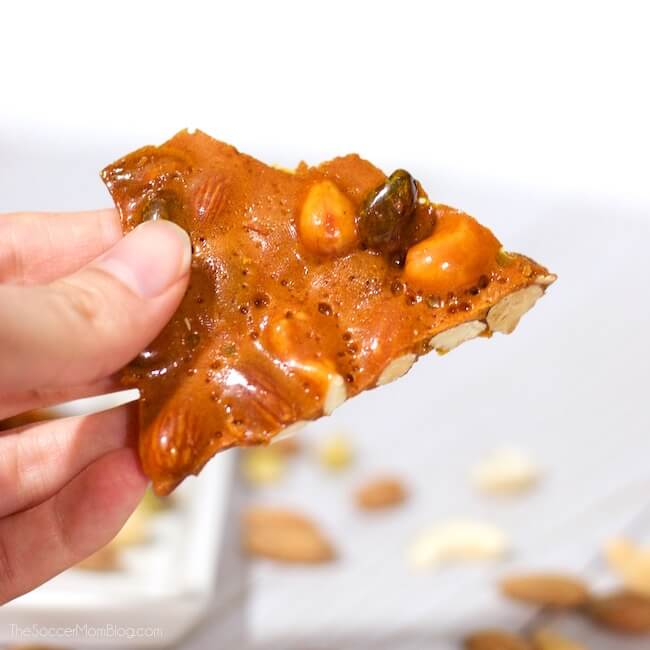 holding a piece of homemade nut and honey candy