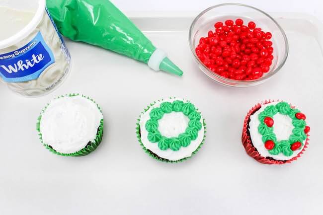 These gorgeous Christmas wreath cupcakes are guaranteed to light up any holiday party! Festive, bright, and way easier to make than you'd expect!