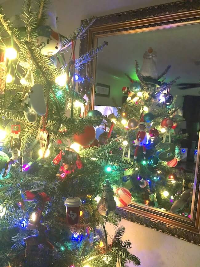 Elf on the Shelf hiding in a Christmas tree