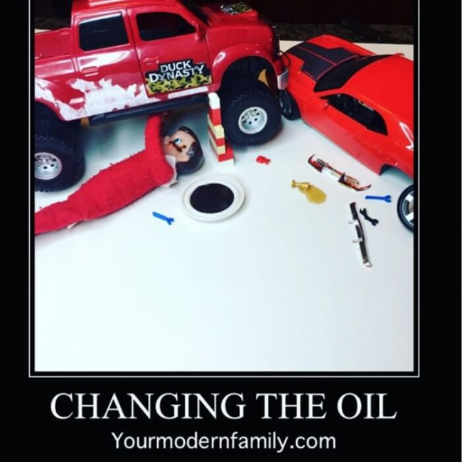Elf doll changing the oil on a toy car