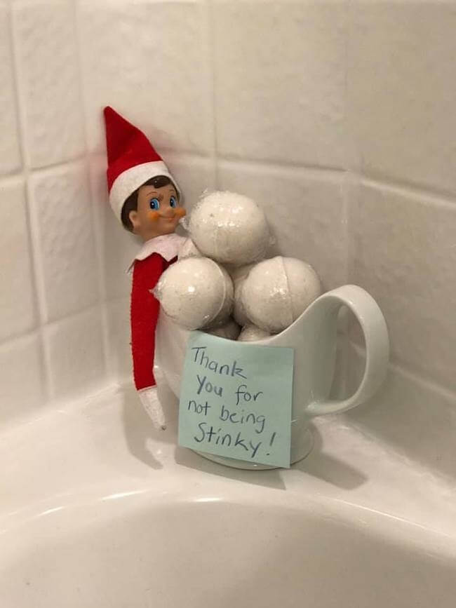 Elf in a mug of bath bombs