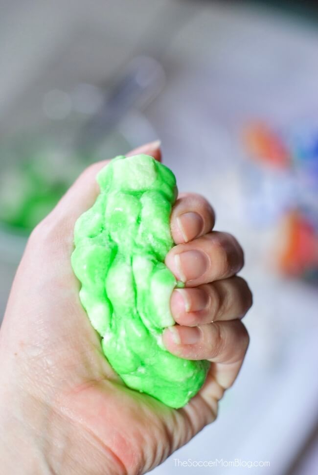 squishing green marshmallow foam slime in hand