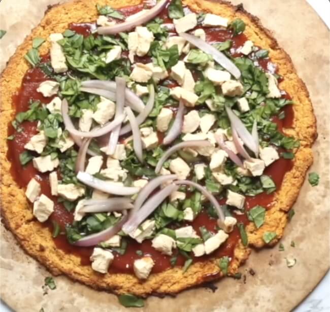 sweet potato pizza crust topped with chicken, spinach, and onions