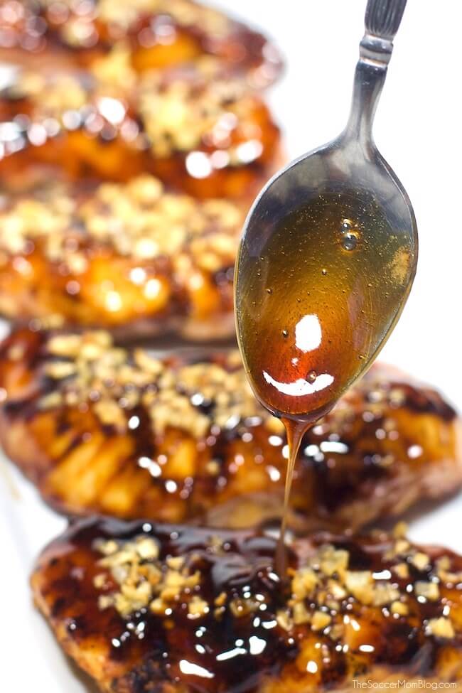 Honey glaze on spoon dripping onto chicken 
