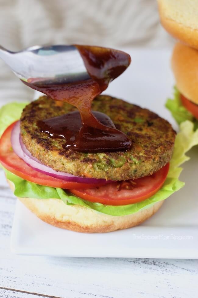 Spreading barbecue sauce on a vegetarian burger
