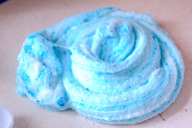 Blue cotton candy slime swirled on table