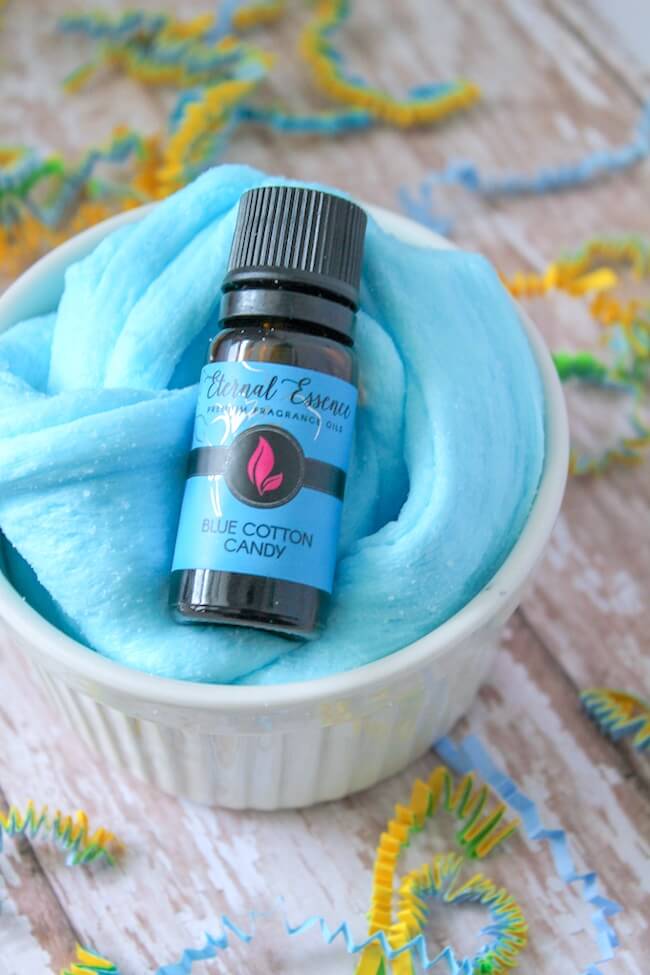 Cotton candy slime in bowl with a bottle of blue cotton candy fragrance