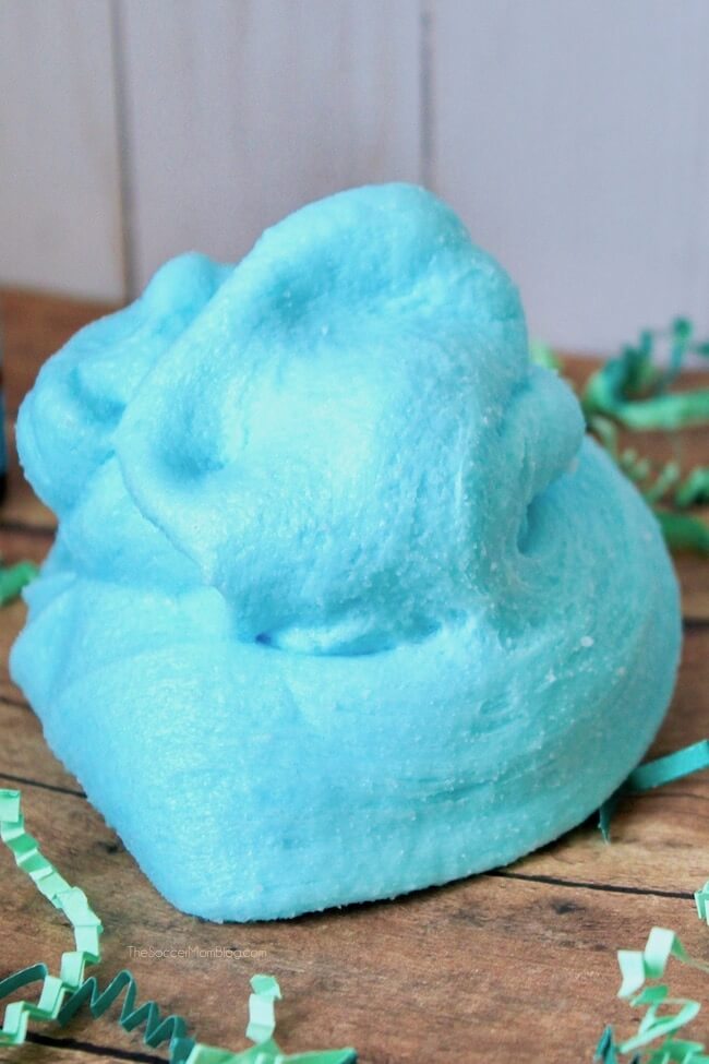 Fluffy blue cotton candy slime on a wooden table