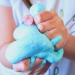 Squishing blue cotton candy slime in hands
