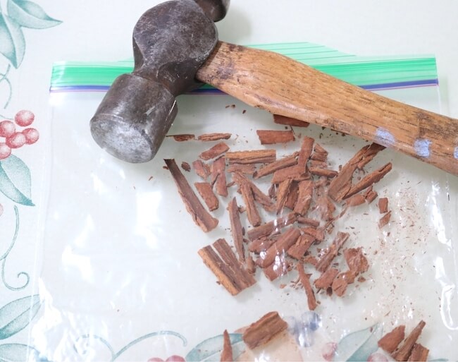 Crushing cinnamon with a hammer to make infused chapstick