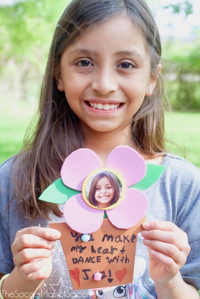 girl holding a handmade flower craft made for mother's day