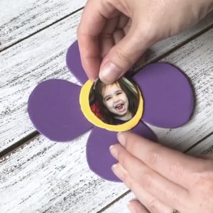 gluing child's photo on a flower craft