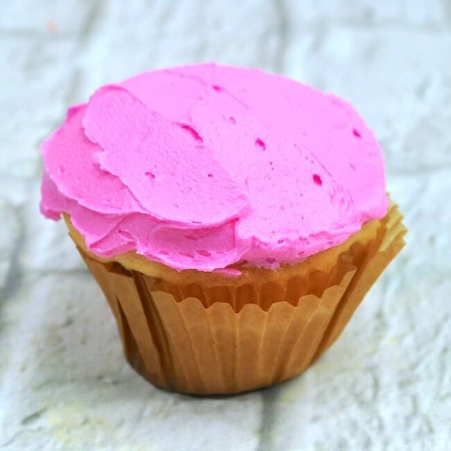 Rózsaszín cukormáz fehér cupcake-re
