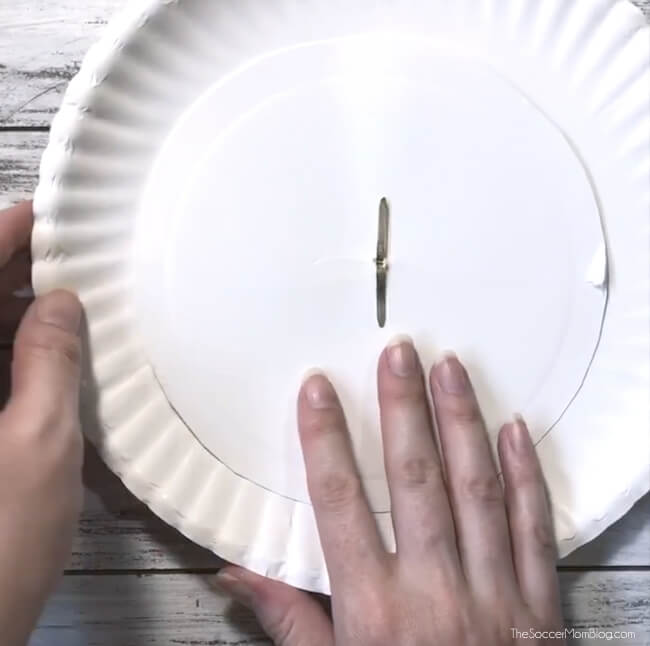 using a brass fastener to attach two paper plates