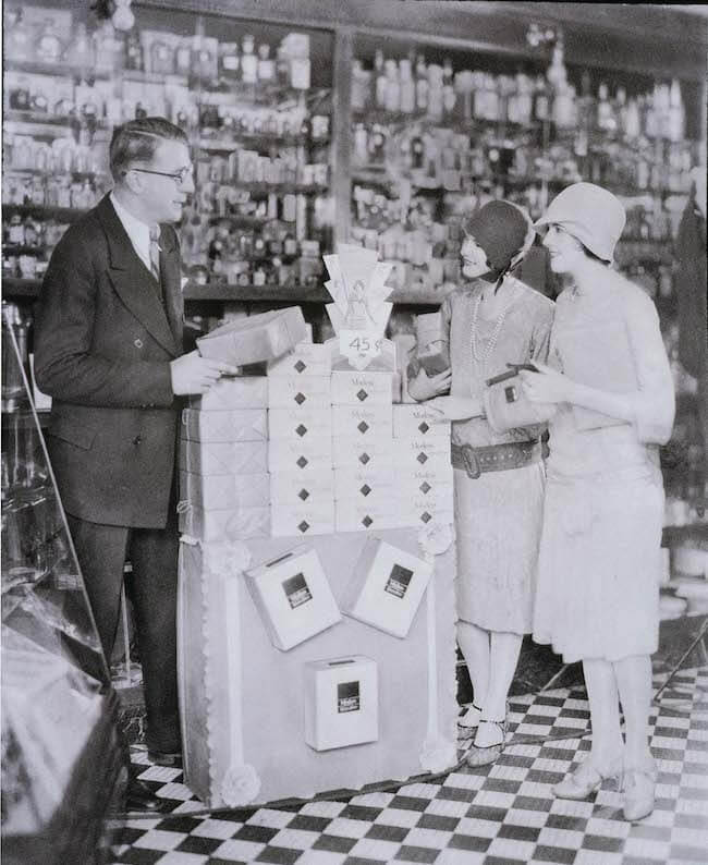 Women line up at store display of Modess tampons circa 1920s