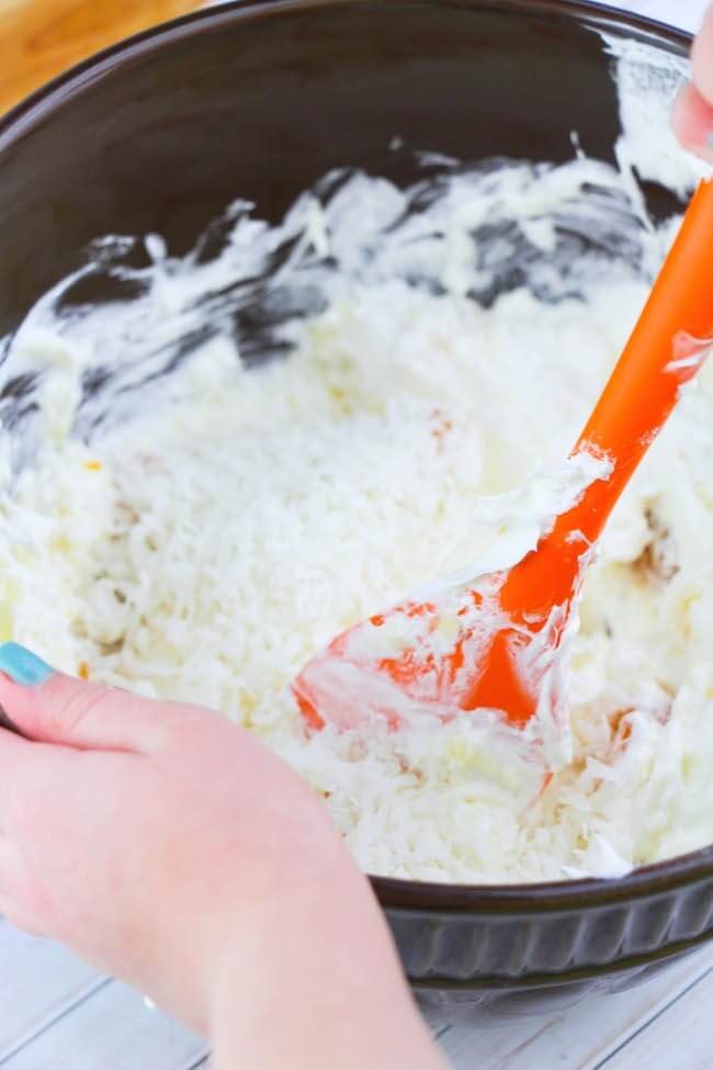 Stirring sour cream and Cool Whip for Ambrosia Salad
