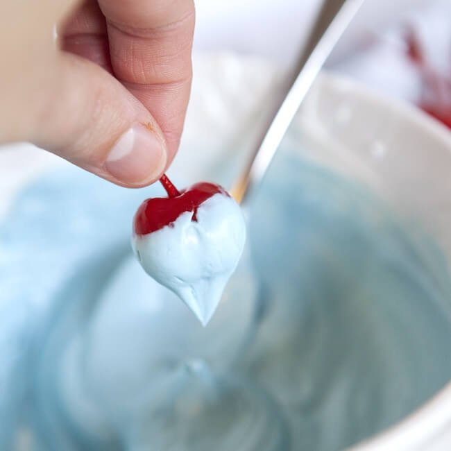 Dipping cherries in blue chocolate for 4th of July