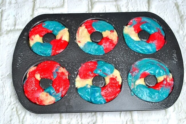 red white and blue swirled batter in a donut pan
