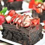 chocolate brownie covered with strawberries and fudge icing