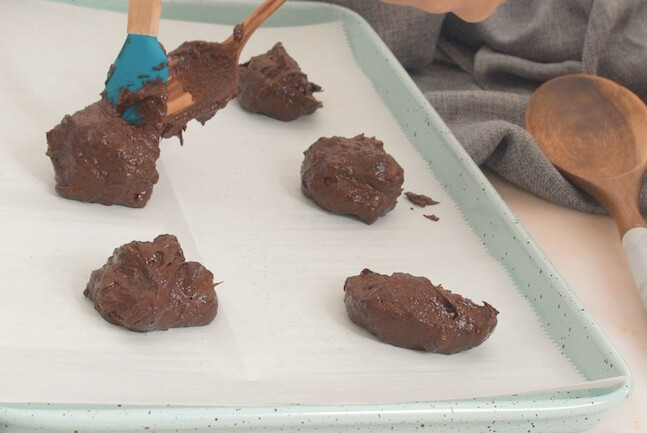 scooping avocado chocolate cookies onto baking sheet