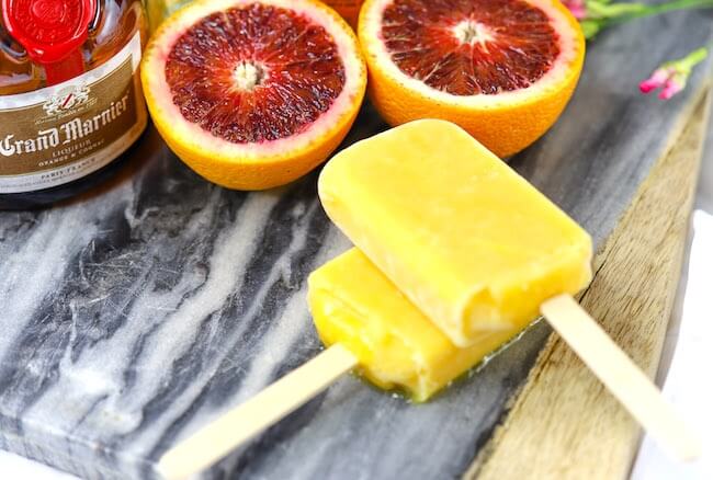 orange popsicles on cutting board