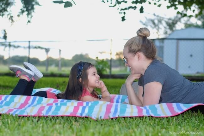 mom and daughter on a picnic blanket in grass