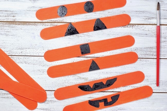 painting pumpkin faces on craft sticks