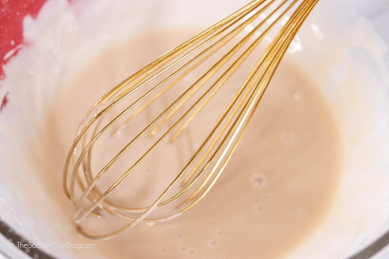 mixing icing with wire whisk