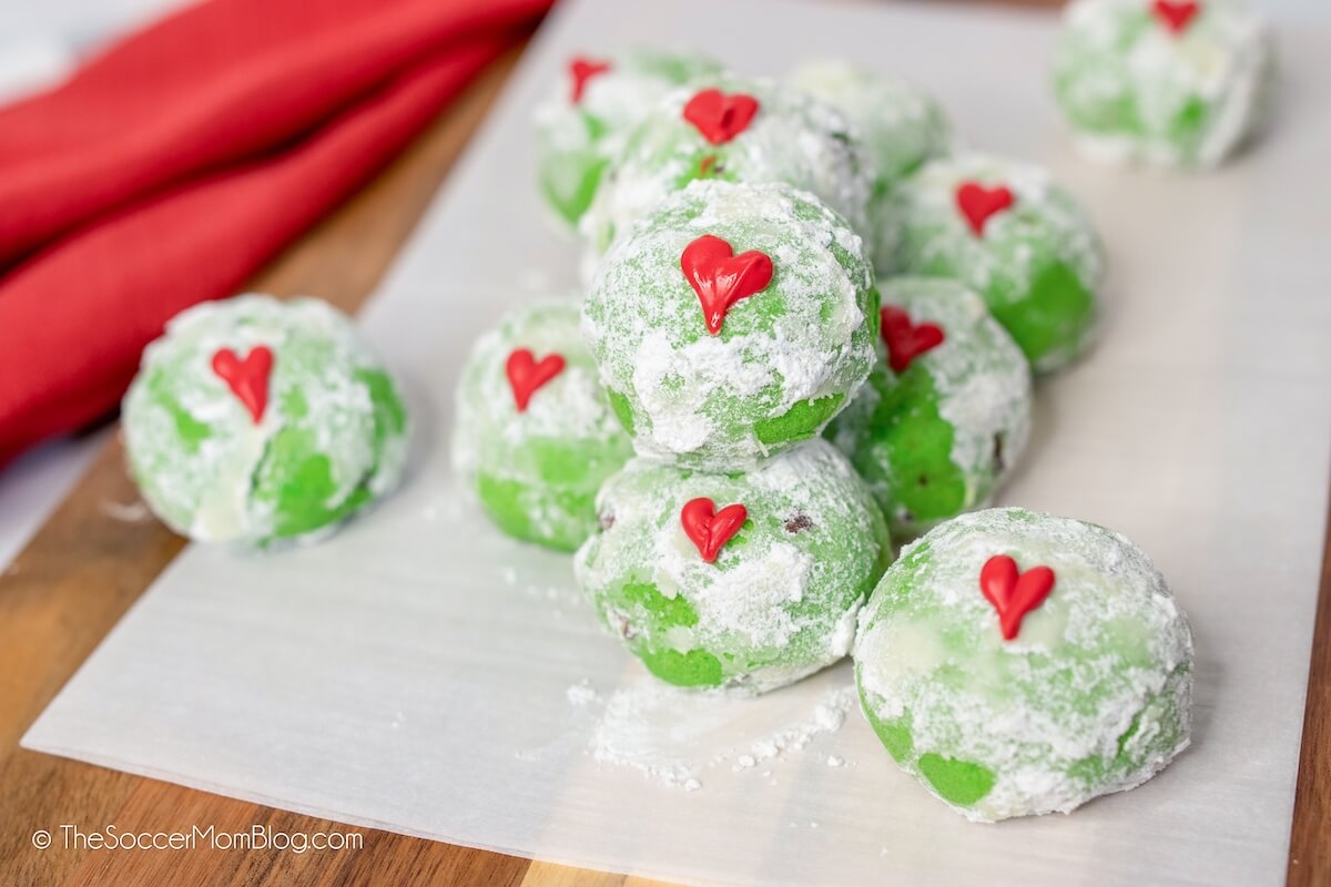 green snowball cookies with a red candy heart, inspired by The Grinch